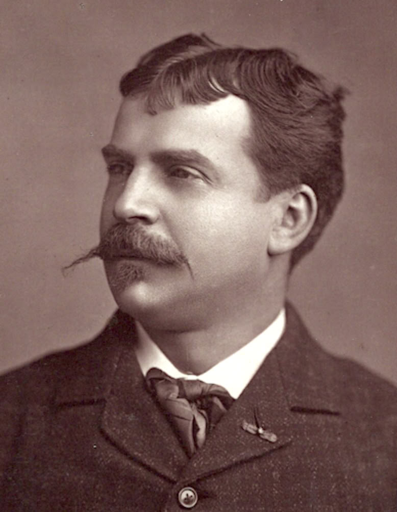 Photographie en noir et blanc de Pierre-Léon MELCHISSEDEC avec une moustache, portant un costume et une cravate, regardant vers la gauche.