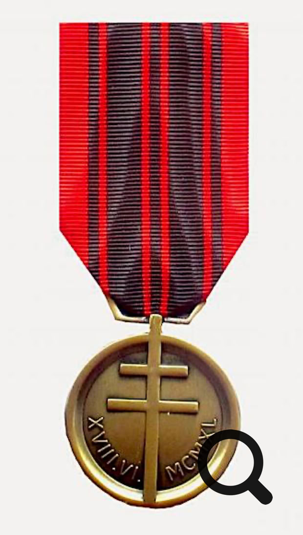 Médaille en bronze avec une croix, suspendue à un ruban rouge et noir.