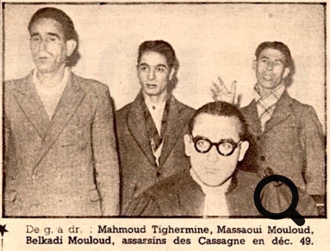 Quatre hommes en costume, dont un portant des lunettes, posent pour une photo en noir et blanc.