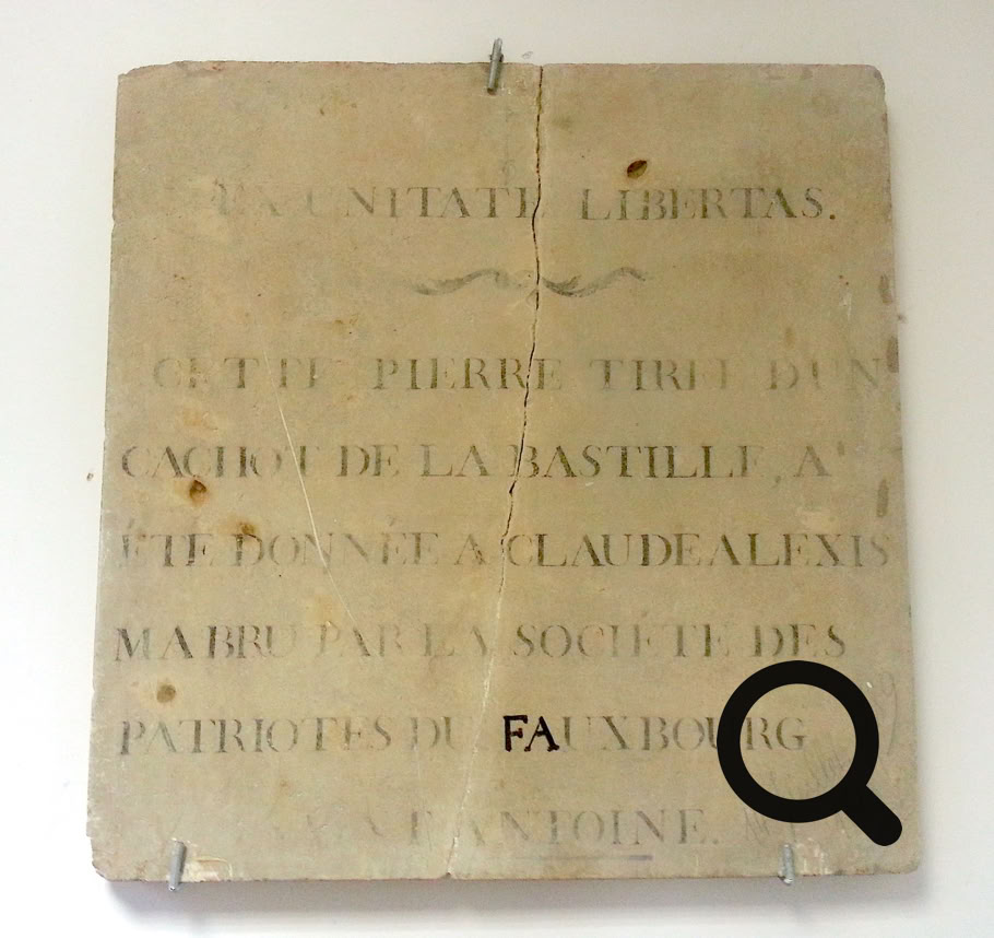 Plaque en pierre avec texte en français, légèrement usée et accrochée au mur.